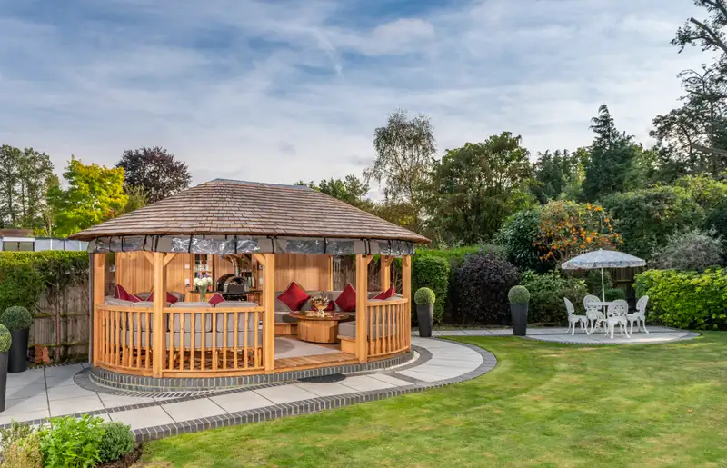 Luxury wooden gazebo with cedar shingle roof and festoon lighting