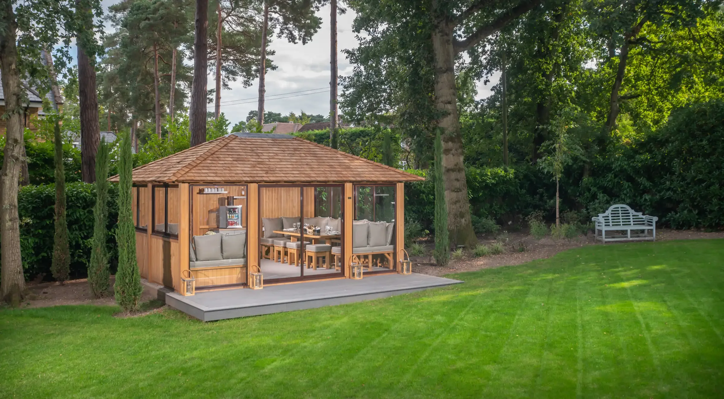 Traditional summer house beneath oak trees in countryside setting